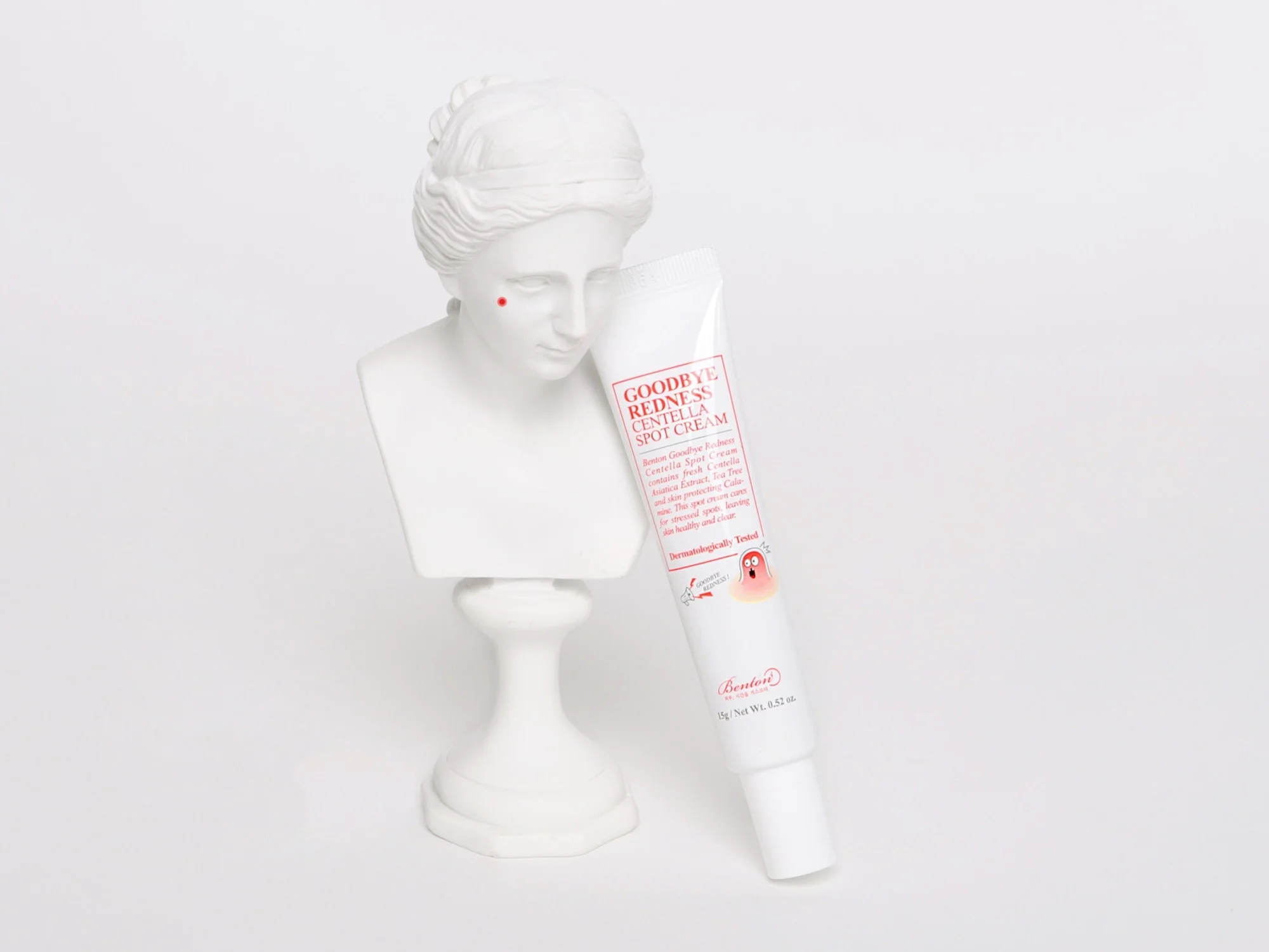 Benton voide, avaamaton tuote, pitkulainen kapeneva muovituubi, kuvassa myös pieni koristepatsas (Goodbye Redness Centella Spot Cream)